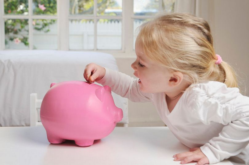 girl puts money in a piggy bank