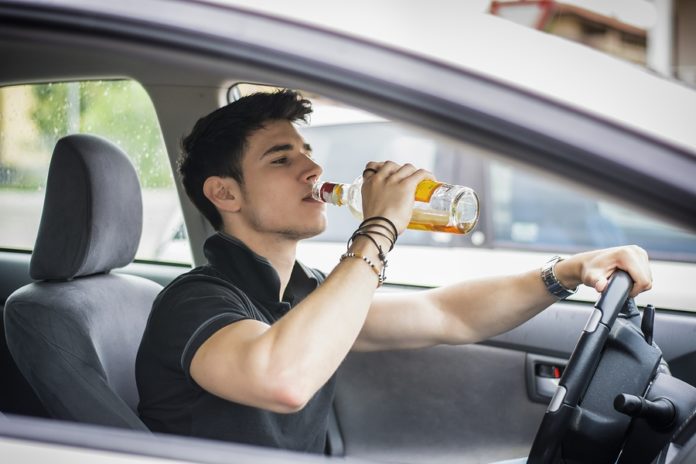 man dricker alkohol under körning
